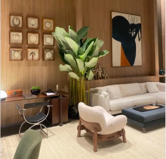 Vista geral do loft com mobiliário curvo, poltronas em tecido bouclé e iluminação suave.