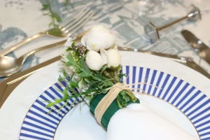 detalhe-de-porta-guardanapo-com-flores-decorativas-em-mesa-posta-classica-com-prato-azul-listrado