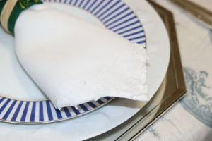 guardanapo-de-linho-branco-dobrado-sobre-prato-decorado-em-mesa-posta-sofisticada