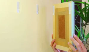 gancho-adesivo-transparente-aplicado-na-parede-para-pendurar-quadros-sem-usar-furadeira