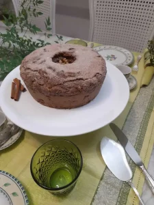 Bolo-de-maca-e-canela-sobre-boleira-branca-servindo-como-elemento-central-da-mesa-posta