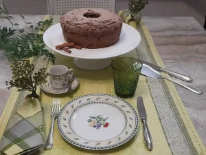 Mesa posta acolhedora inspirada no estilo europeu com trilho português, louças delicadas e bolo caseiro.