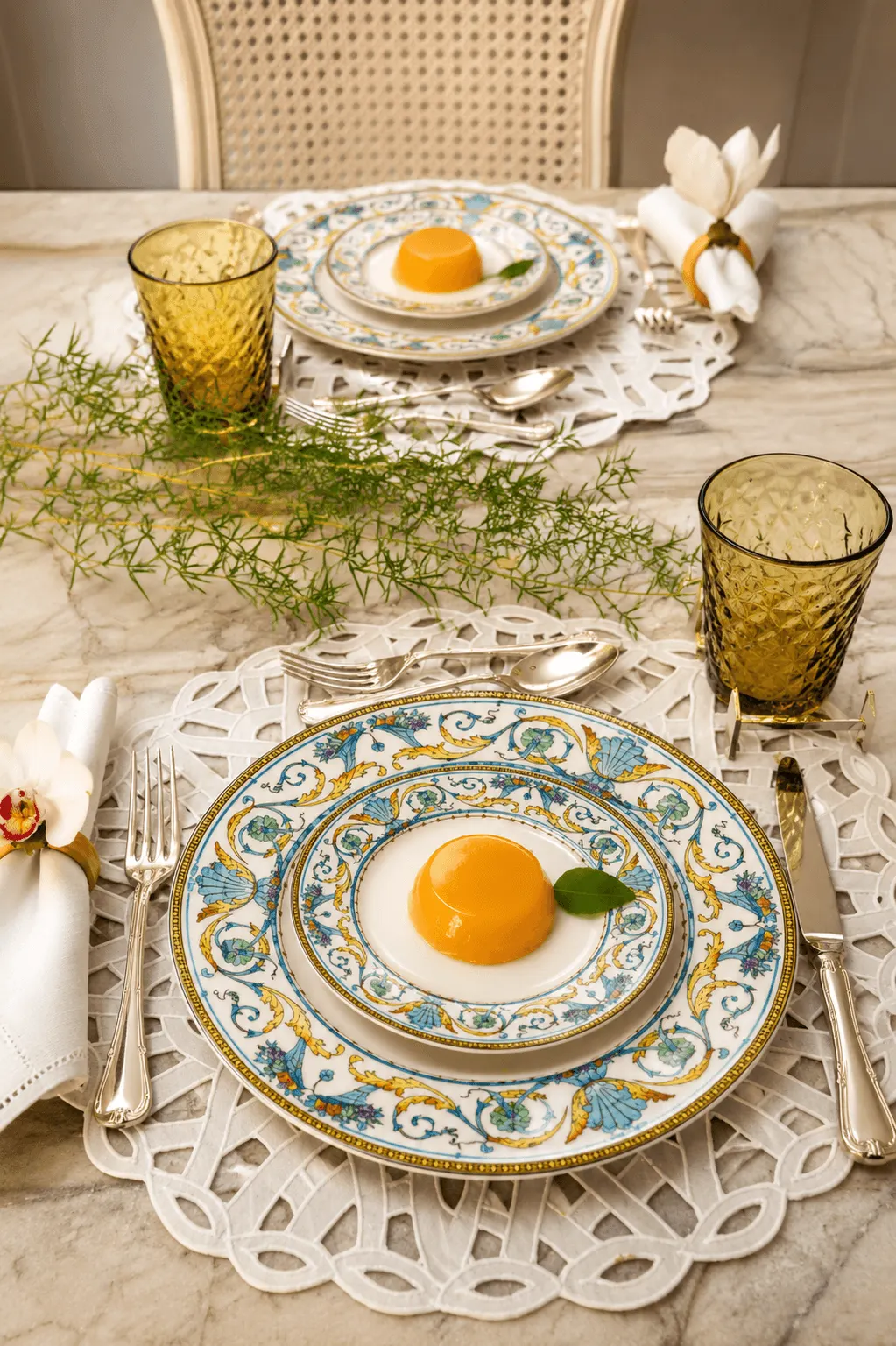 Mesa-posta-elegante-com-louca-Mikasa-azul-e-amarela-copos-Balloton-Maca-Verde-Zafferano-folhagens-naturais-e-quindim-sobre-mesa-de-marmore.