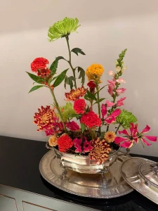 Arranjo-floral-organico-com-flores-em-tons-de-rosa-vermelho-amarelo-e-verde-sobre-base-de-musgo-natural.