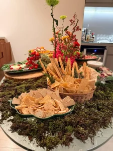 Cestos-com-paes-artesanais-crackers-e-torradas-compondo-mesa-inspirada-em-jardim-com-musgo-natural-e-flores-coloridas