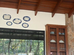 Composicao-decorativa-com-pratos-travessas-e-loucas-de-diferentes-formatos-organizadas-em-parede-de-forma-harmoniosa