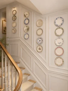 Escada-em-estilo-ingles-contemporaneo-decorada-com-porcelanas-azuis-e-brancas-travessas-ornamentais-e-composicao-de-pratos-que-valoriza-a-personalidade-da-casa.