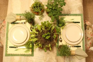 Mesa-posta-com-ervas-aromaticas-e-mini-horta-central-em-composicao-botanica-com-jogo-americano-estampado-e-loucas-em-tons-naturais