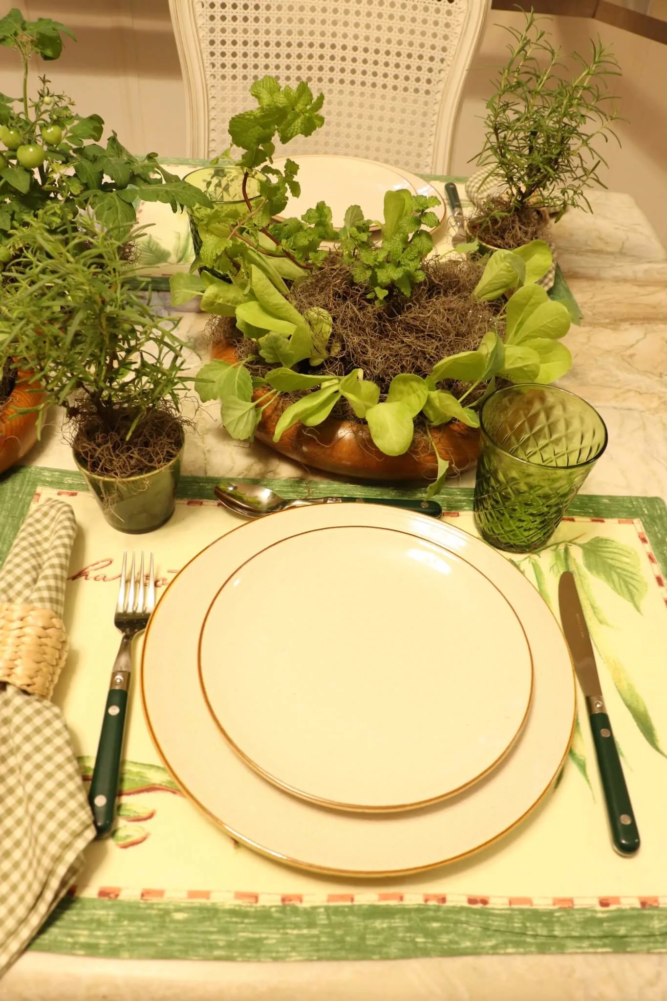 Mesa posta com ervas aromáticas, hortaliças e louças neutras em composição inspirada na natureza e na horta doméstica