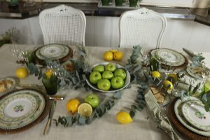 Prato-decorado-com-frutas-em-mesa-posta-com-limoes-sicilianos-macas-verdes-e-eucalipto