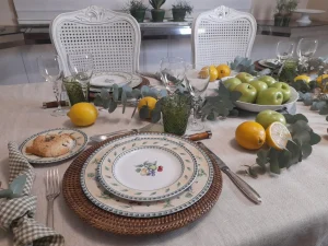 Prato decorado com frutas em mesa posta com limões sicilianos, maçãs verdes e eucalipto