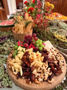 Tabua-de-queijos-uvas-castanhas-e-frutas-secas-integrada-a-decoracao-floral-inspirada-na-natureza.
